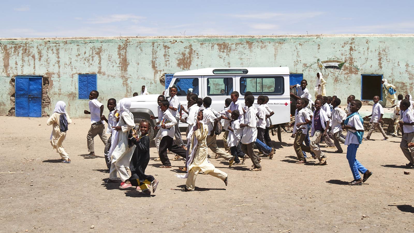 Children surrounding a Land Rover Defender
